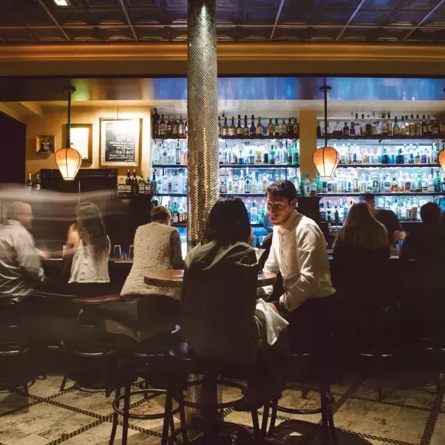 Um casal 和partilha bebidas em um bar movimentado de São Francisco.